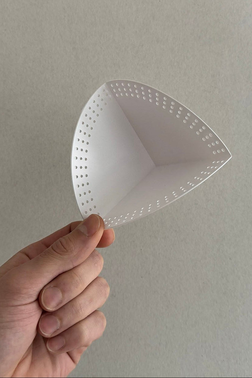 Hand holding a white plaster corner against a plain background